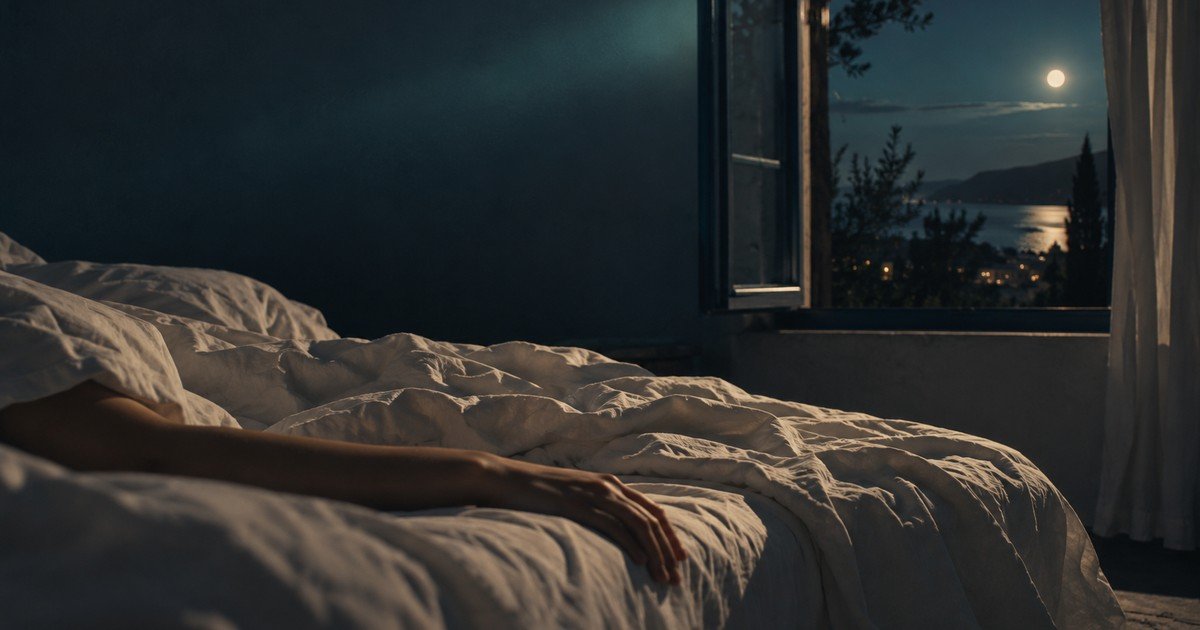 Lit défait et drap léger devant une fenêtre ouverte sur la nuit — pourquoi on dort mal quand il fait chaud